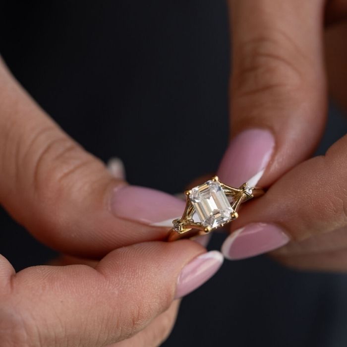 woman-holding-The-Celeste-Emerald-Cut-Diamond-Engagement-Ring-with-Split-Shank-and-Diamond-Accents