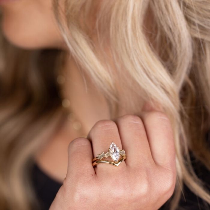 woman-with-gold-marquise-engagement-ring-on-hand