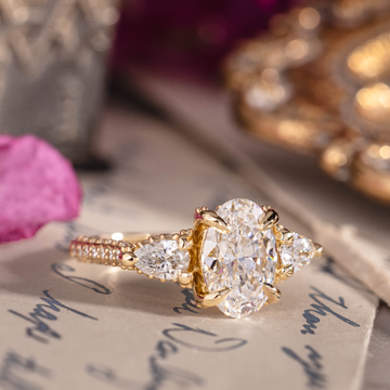 Three-stone custom diamond engagement ring with oval center