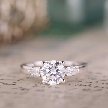 the-odette-three-stone-round-diamond-engagement-ring-pear-shaped-diamond-side-stones