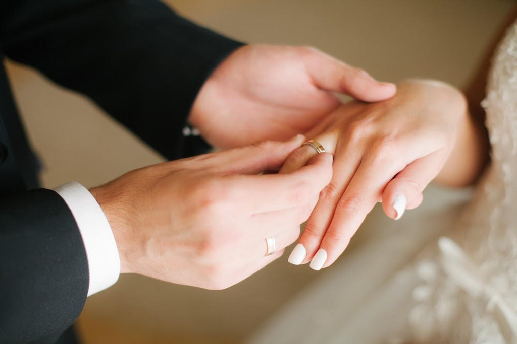 Hands of a wedding couple with rings on a wooden bench - a Royalty Free  Stock Photo from Photocase