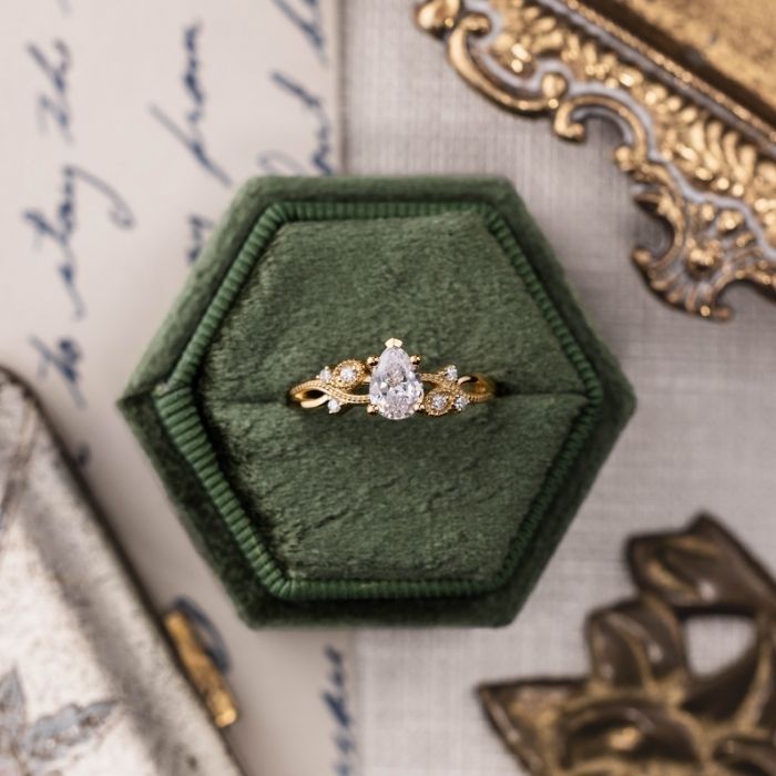 The-Larkwood-Pear-Shaped-Diamond-Engagement-Ring-with-Nature-Inspired-Milgrain-&-Diamond-Accents-on-green-ring-box