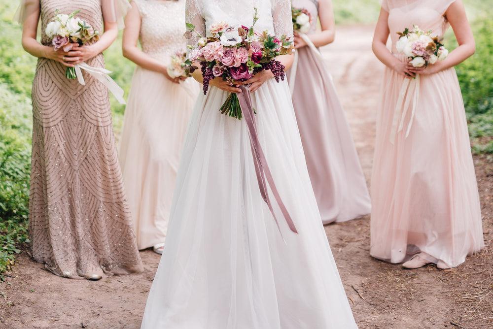 bride with bridesmaids holding bouquets