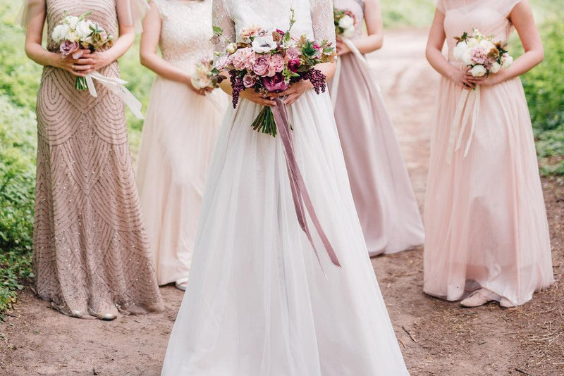 bride with bridesmaids holding bouquets