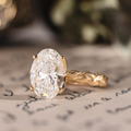 Oval lab-grown diamond engagement ring in 14K yellow gold with hand-engraved leaf band