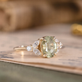 Oval green sapphire engagement ring with marquise diamond accents in 14K yellow gold