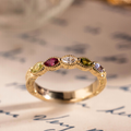 Vintage marquise family ring with ruby, tanzanite, peridot, tourmaline, and diamond accents in 18K yellow gold