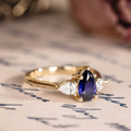 Pear cut lab-grown blue sapphire engagement ring with diamond accents in 14K yellow gold