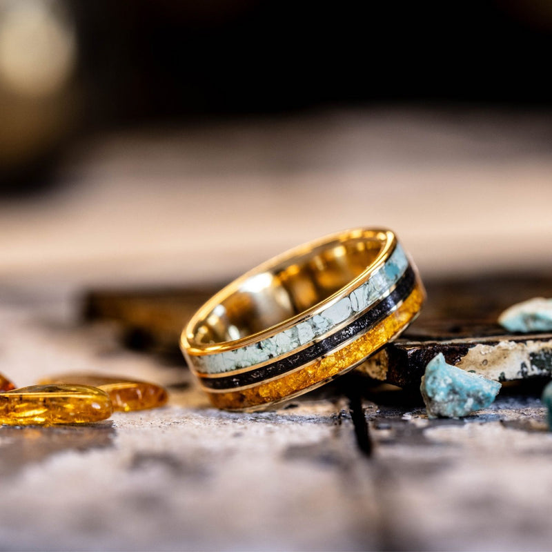 Gold ring with turquoise inlay on a rustic wooden surface