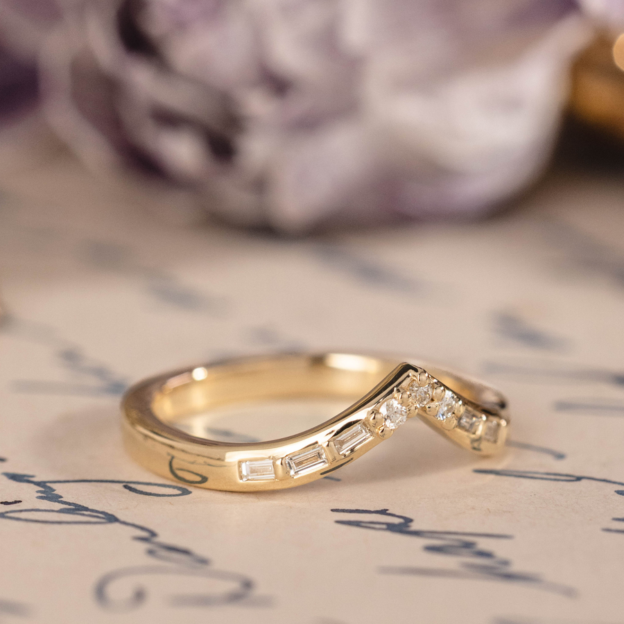 Chevron wedding band with round and baguette diamond accents in 14K yellow gold
