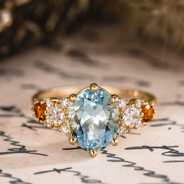 Custom oval aquamarine engagement ring with matching contour band and citrine stones