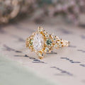 Custom Floral Vine–Inspired Oval Moissanite Engagement Ring with Green Sapphire Accents