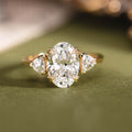 Custom three stone oval diamond engagement ring with trillion cut diamonds