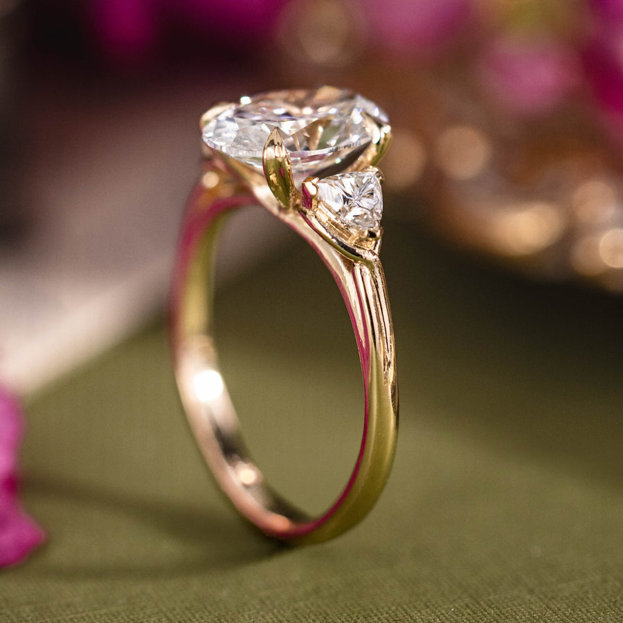 Custom three stone oval diamond engagement ring with trillion cut diamonds