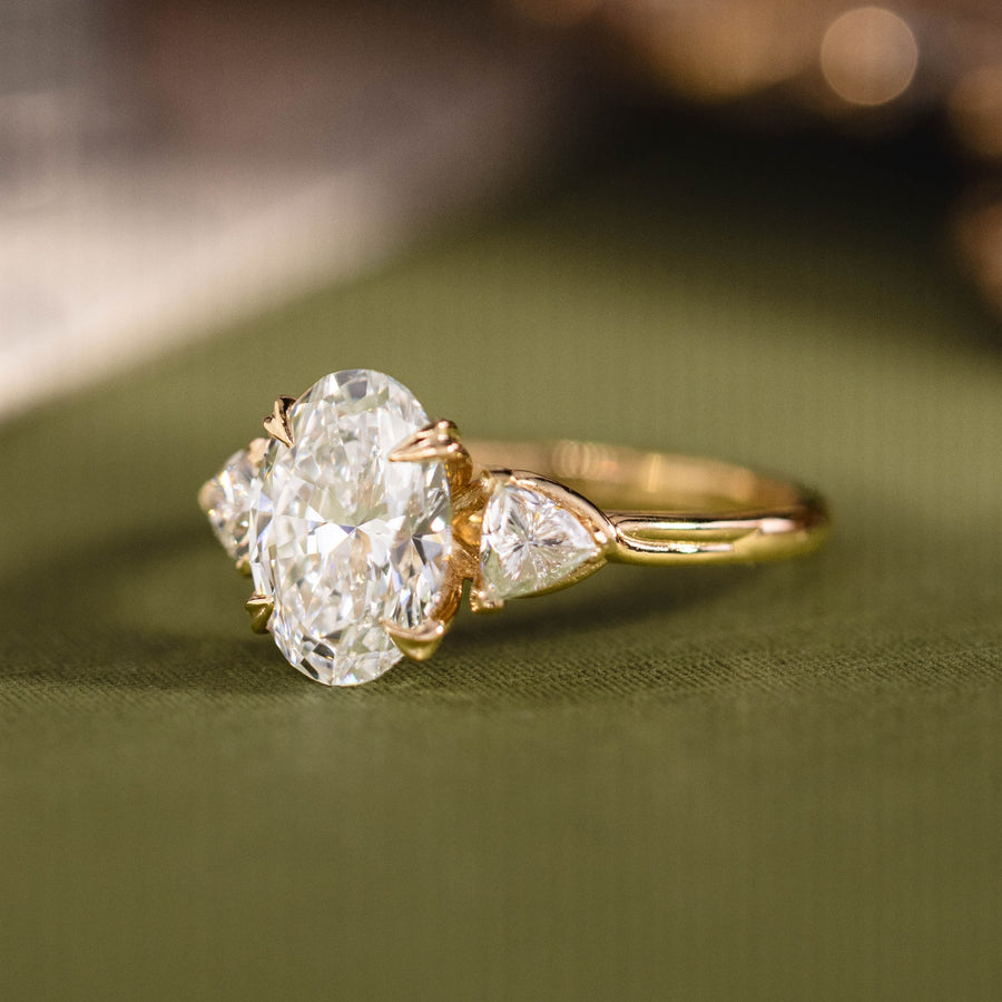 Custom three stone oval diamond engagement ring with trillion cut diamonds