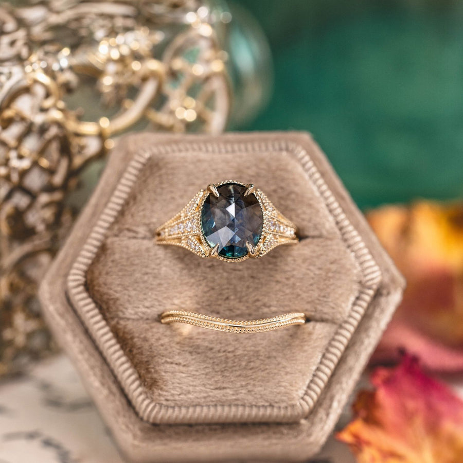 A custom Amelie engagement ring with a center rose cut teal sapphire