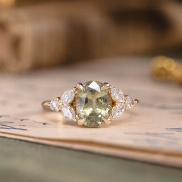 Oval green sapphire engagement ring with marquise diamond accents in 14K yellow gold