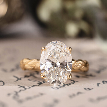 Oval lab-grown diamond engagement ring in 14K yellow gold with hand-engraved leaf band