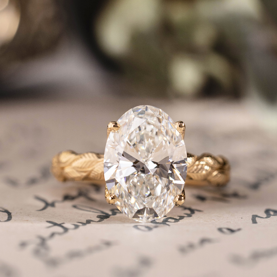 Oval lab-grown diamond engagement ring in 14K yellow gold with hand-engraved leaf band