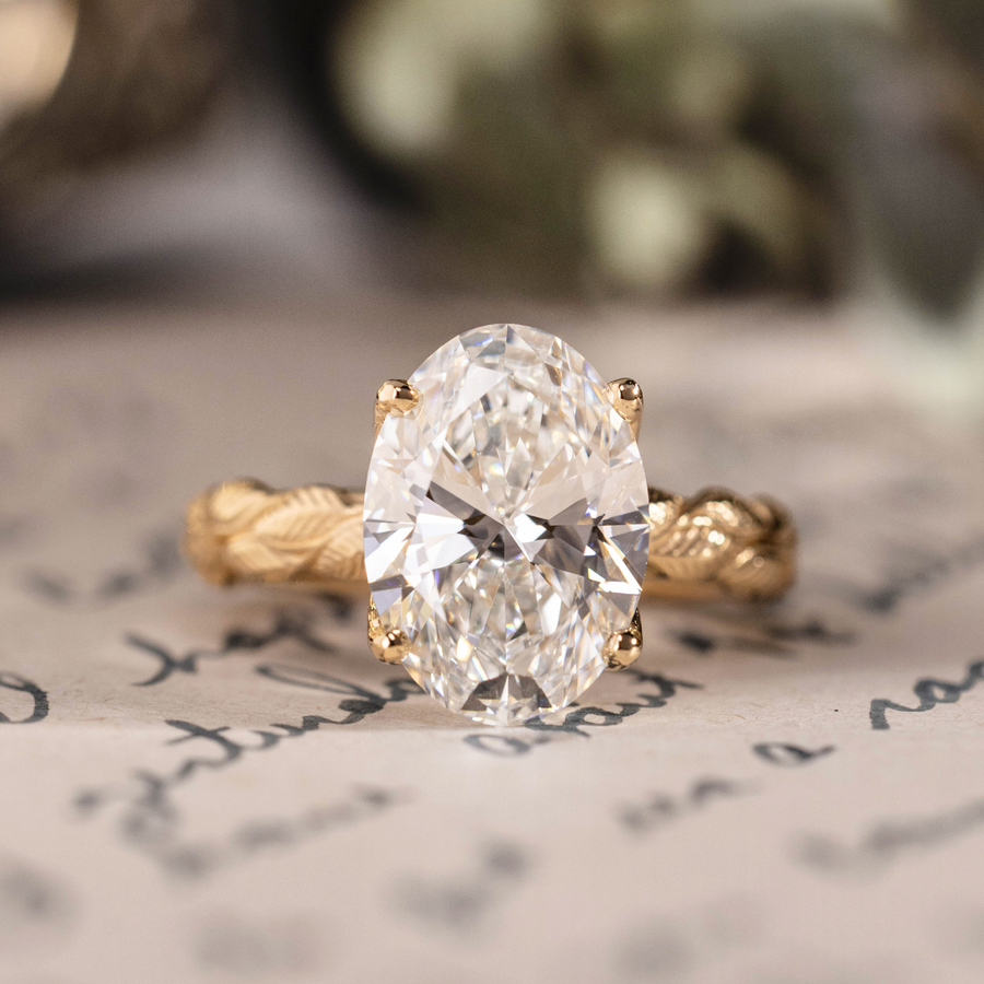 Oval lab-grown diamond engagement ring in 14K yellow gold with hand-engraved leaf band