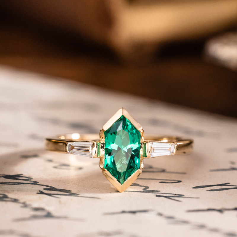 Hexagon cut emerald engagement ring with baguette diamond accents