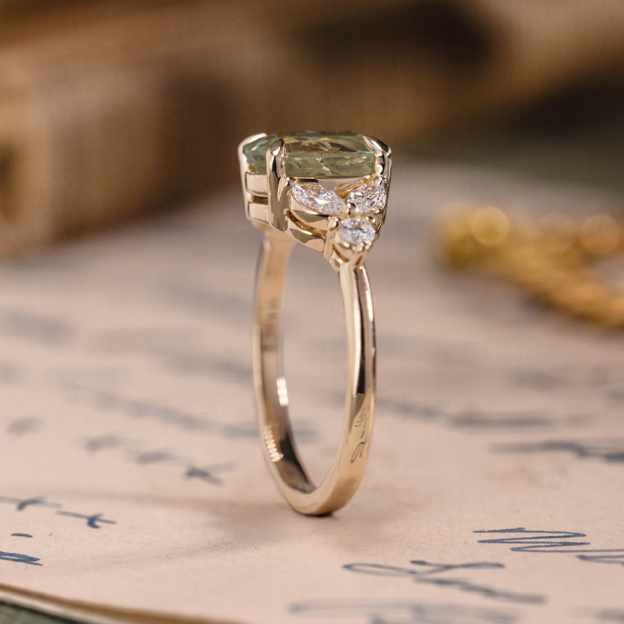 Oval green sapphire engagement ring with marquise diamond accents in 14K yellow gold