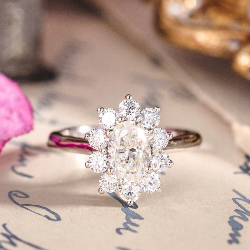 Oval diamond engagement ring with cluster halo in white gold