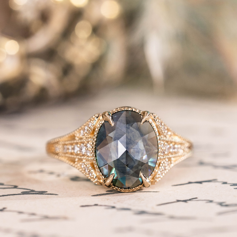 Oval gray sapphire engagement ring in ornate gold pave setting