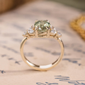Oval green sapphire engagement ring with marquise diamond accents in 14K yellow gold