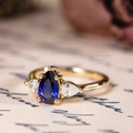 Pear cut lab-grown blue sapphire engagement ring with diamond accents in 14K yellow gold