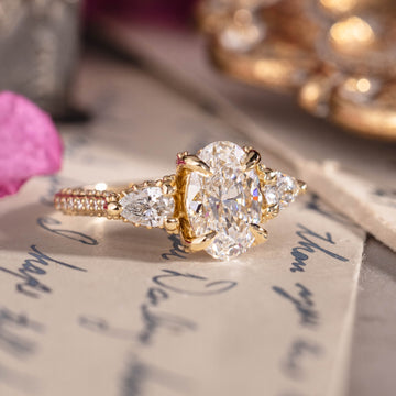 Three-stone custom diamond engagement ring with oval center