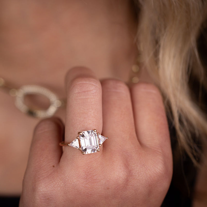 Emerald-cut-diamond-three-stone-engagement-ring-trillion-diamond-accent-stones-the-ingrid-rustic-and-main