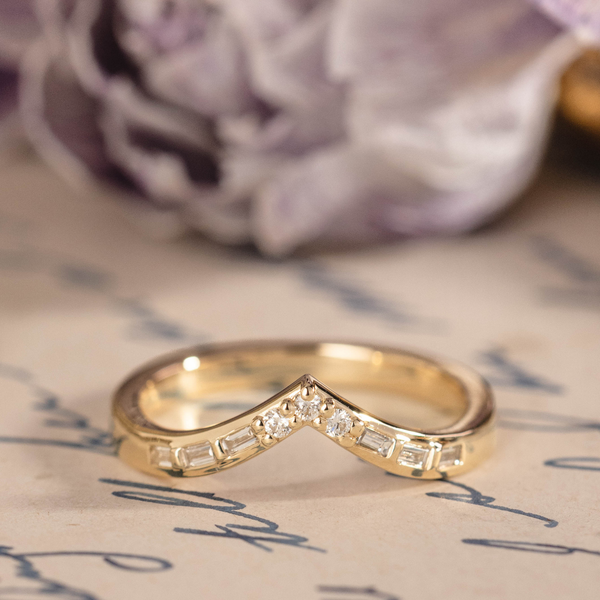 Chevron wedding band with round and baguette diamond accents in 14K yellow gold