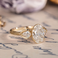 Oval diamond three-stone engagement ring with pear accents in 14K yellow gol