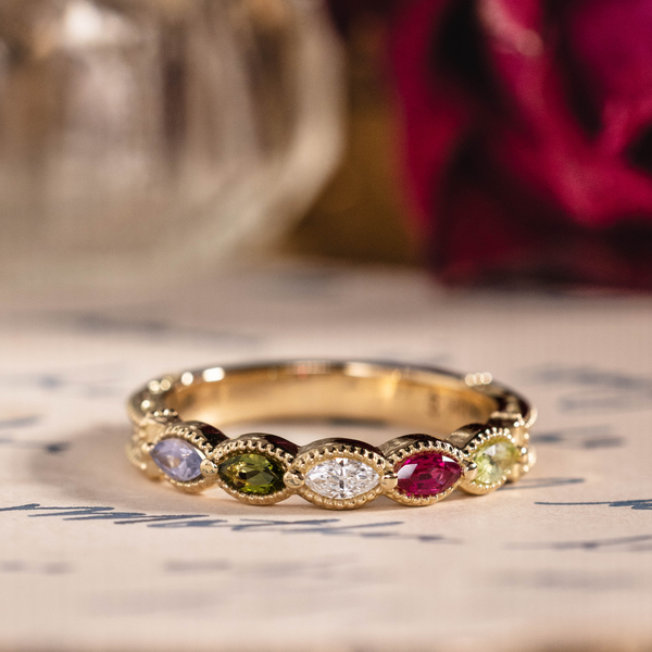 Vintage marquise family ring with ruby, tanzanite, peridot, tourmaline, and diamond accents in 18K yellow gold