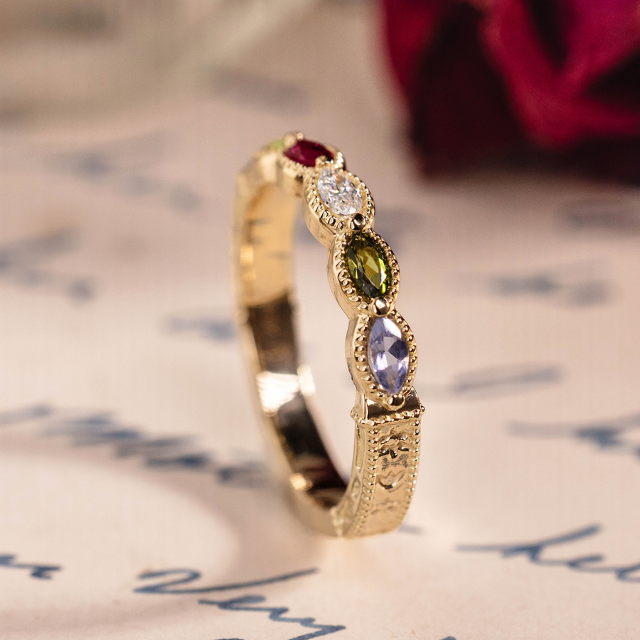 Vintage marquise family ring with ruby, tanzanite, peridot, tourmaline, and diamond accents in 18K yellow gold