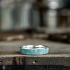 Silver ring with turquoise inlay on a wooden surface