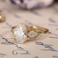 Oval diamond three-stone engagement ring with pear accents in 14K yellow gold