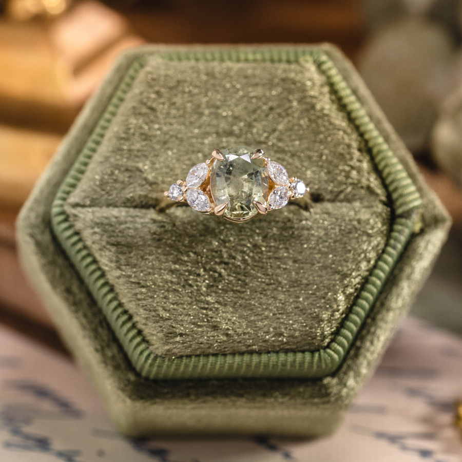 Oval green sapphire engagement ring with marquise diamond accents in 14K yellow gold