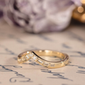 Chevron wedding band with round and baguette diamond accents in 14K yellow gold