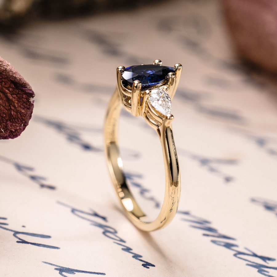 Pear cut lab-grown blue sapphire engagement ring with diamond accents in 14K yellow gold