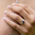 blue-sapphire-pear-cut-three-stone-engagement-ring-with-diamond-accents