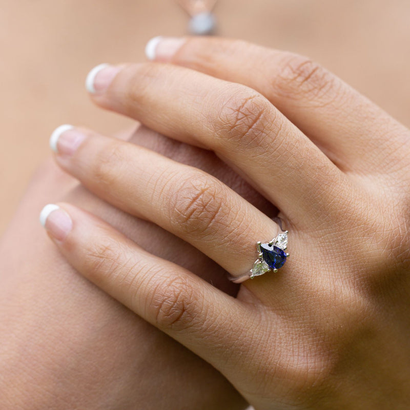 blue-sapphire-pear-cut-three-stone-engagement-ring-with-diamond-accents