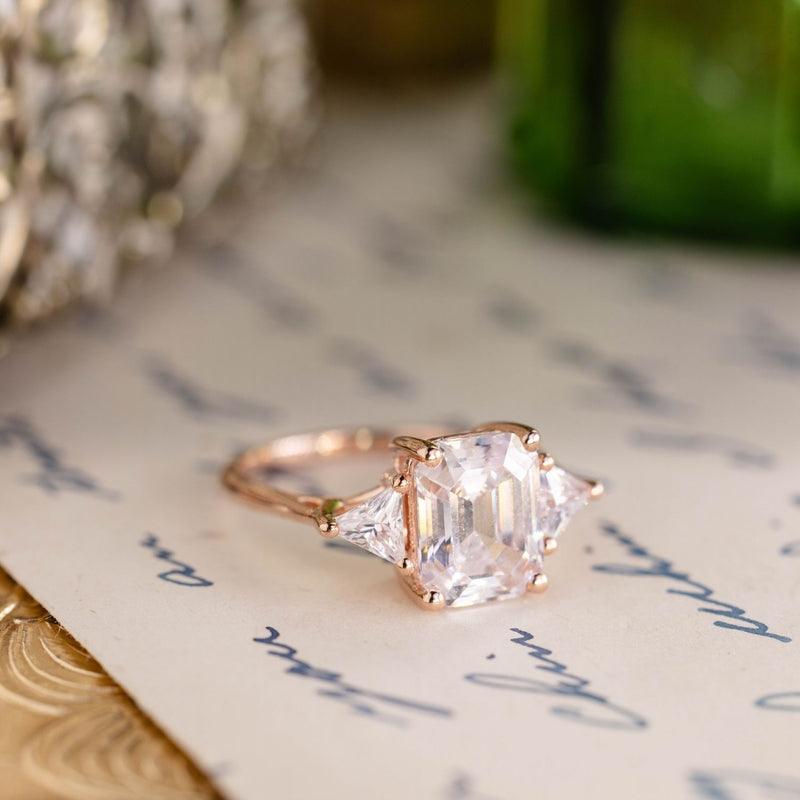 Emerald-cut-diamond-three-stone-engagement-ring-trillion-diamond-accent-stones-the-ingrid-rustic-and-main