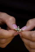 Close-up video of The Titania gold ring worn on hand, featuring a marquise-cut moss agate center stone with sparkling diamond and green gemstone accents along the band.