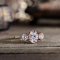 oval-diamond-three-stone-engagement-ring-round-diamond-accents-trilogy-the-wren-rustic-and-main