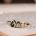 the-lyra-bezel-set-pear-cut-blue-sapphire-engagement-ring-diamond-accents