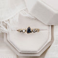 the-lyra-bezel-set-pear-cut-blue-sapphire-engagement-ring-diamond-accents