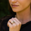 Lifestyle view of The Titania yellow gold ring worn on hand, highlighting the marquise moss agate center stone and nature-inspired green and clear gemstone accents.