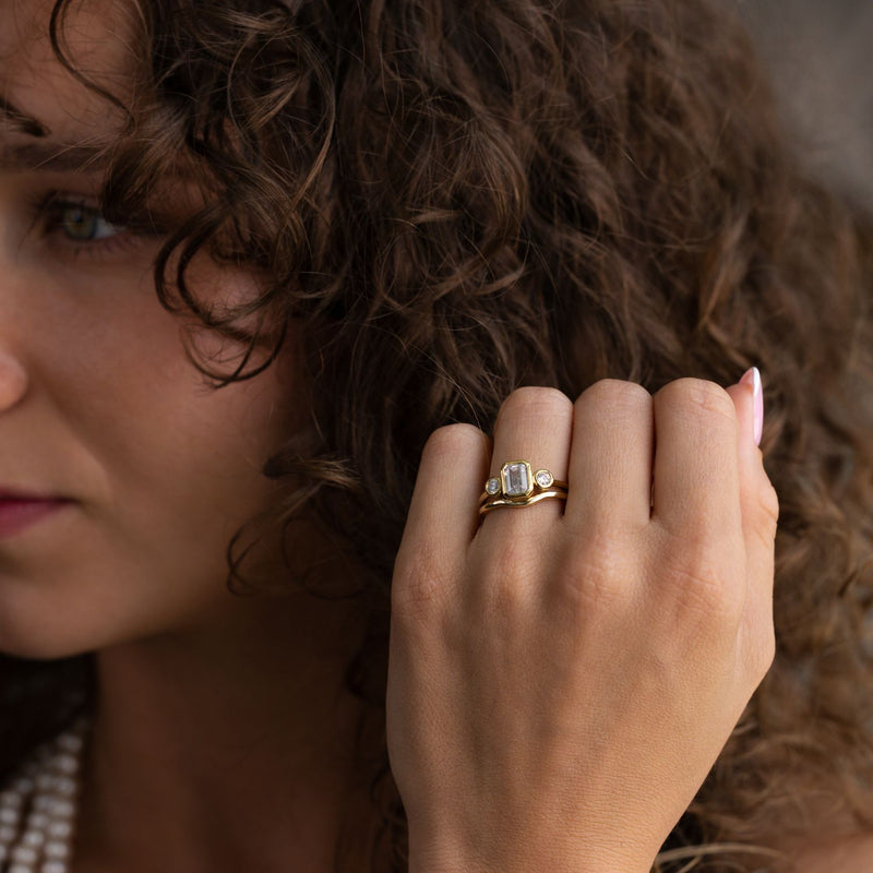 three-stone-emerald-cut-diamond-engagement-ring-round-diamond-accents-bezel-setting-the-marcelline-rustic-and-main